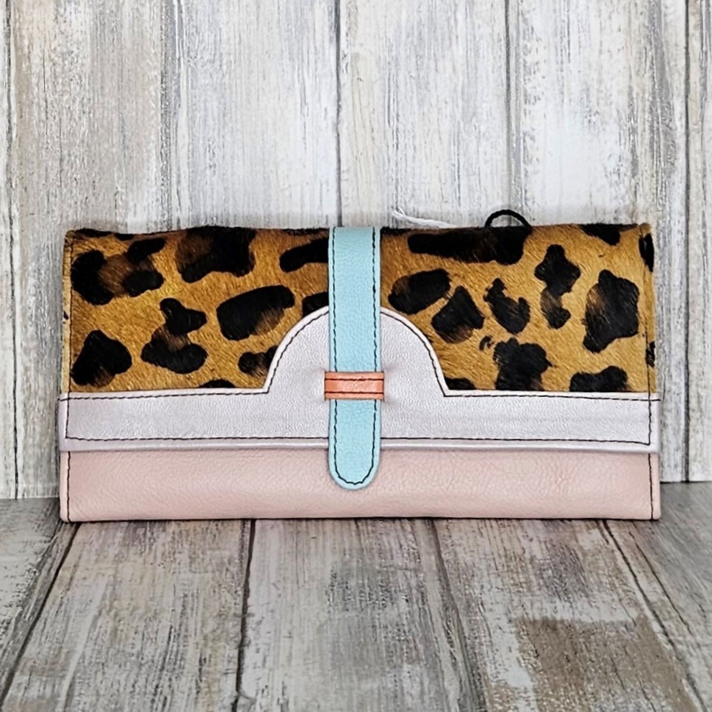 The Soruka Purse-68746-Cheetah/Pink/Orange makes a bold statement with its vibrant colours and upcycled leather. Not only eco-friendly, this purse is also fair trade, ensuring ethical production methods. With plenty of card slots and a coin section, this colourful and soft leather purse is perfect for day-to-day use! Carrying your everyday essentials has never looked so good.  Each Soruka bag and purse comes to you in a beautiful recycled Sari gift bag.  L:20.5cm W:2.5cm H:10cm