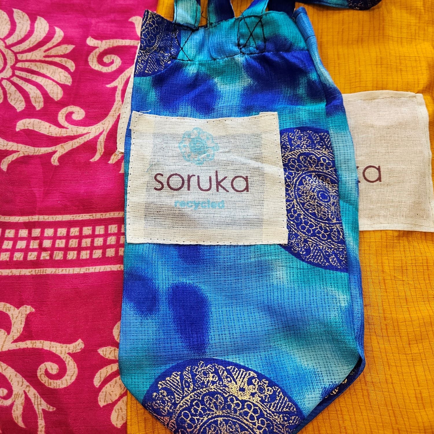 The Maya Soruka Handbag  provides a slim and attractive design with zip pockets to keep valuable items secure and accessible. With an adjustable strap, an inner pocket, and the ability to wear as a shoulder bag or cross body, it is the ideal accessory for any occasion.  Each Soruka bag and large purse comes to you in a beautiful recycled Sari gift bag.  L:18cm x H:21cm