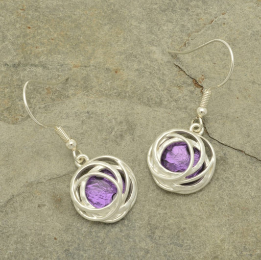 Make a bold statement with the Bright Purple and Silver Drop Earrings! These stunning earrings feature a beautiful bold purple resin backed by aluminium foil and surrounded by matt silver hooped metalwork, creating a unique and captivating blend of color and texture. Be glamorous and daring with these one-of-a-kind earrings!  These earrings are  approx 1.5cm in diameter and hang approx 2cm down from fishhooks.