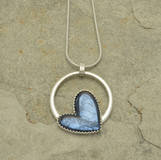 This denim blue necklace is a captivating addition to any jewellery collection. Expertly crafted with a resin heart on a silver hoop, the necklace catches light with aluminum foil backing to create texture and depth. Featuring a lobster clasp and 8 cm extension chain, it measures 41 cm in length.