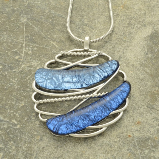 This beautiful pendant is crafted with a unique combination of royal blue and powder blue foiled resin set in a silver framework, creating an eye-catching piece. The pendant measures 4cm in diameter and comes with a 41cm snake chain and 8cm extender, secured with a lobster clasp.