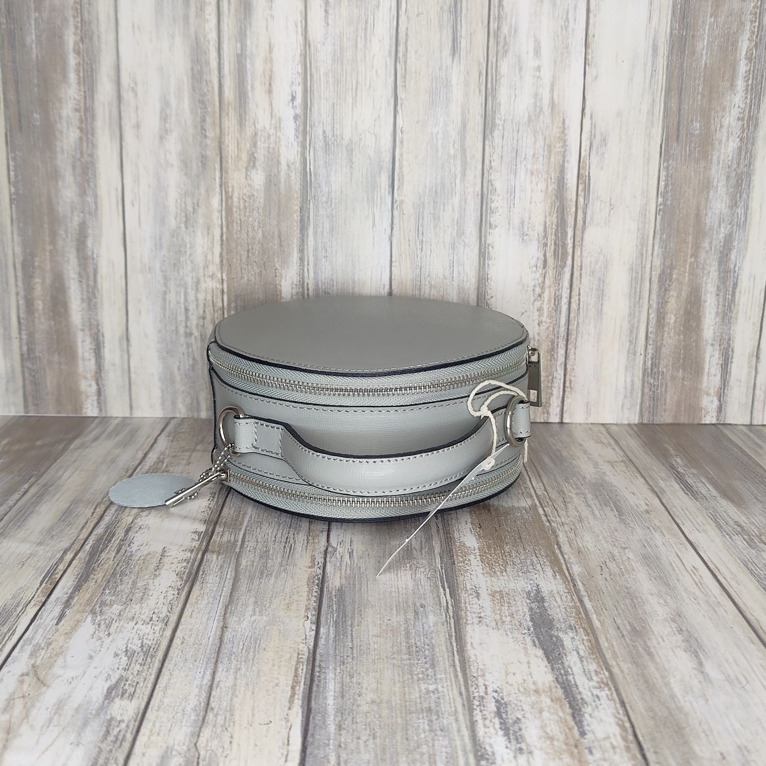 This stylish Italian leather round grab bag is an essential addition to any wardrobe. With a two-zip closure and unique shape, it is a versatile accessory for any occasion. The bag also features a convenient grab handle as well as a detachable long crossbody strap.   Maximum handle drop 60cm   Silver hardware   h:19cm x w19cm x d8cm 