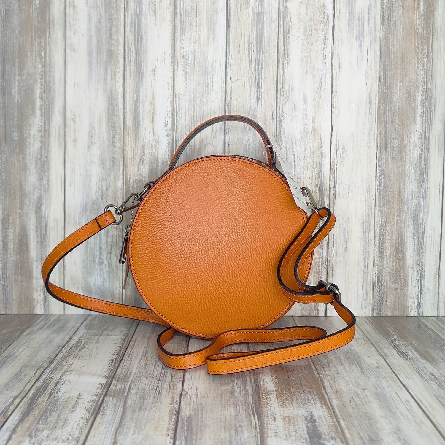 This stylish Italian leather round grab bag is an essential addition to any wardrobe. With a two-zip closure and unique shape, it is a versatile accessory for any occasion. The bag also features a convenient grab handle as well as a detachable long crossbody strap.   Maximum handle drop 60cm   Silver hardware   h:19cm x w19cm x d8cm 