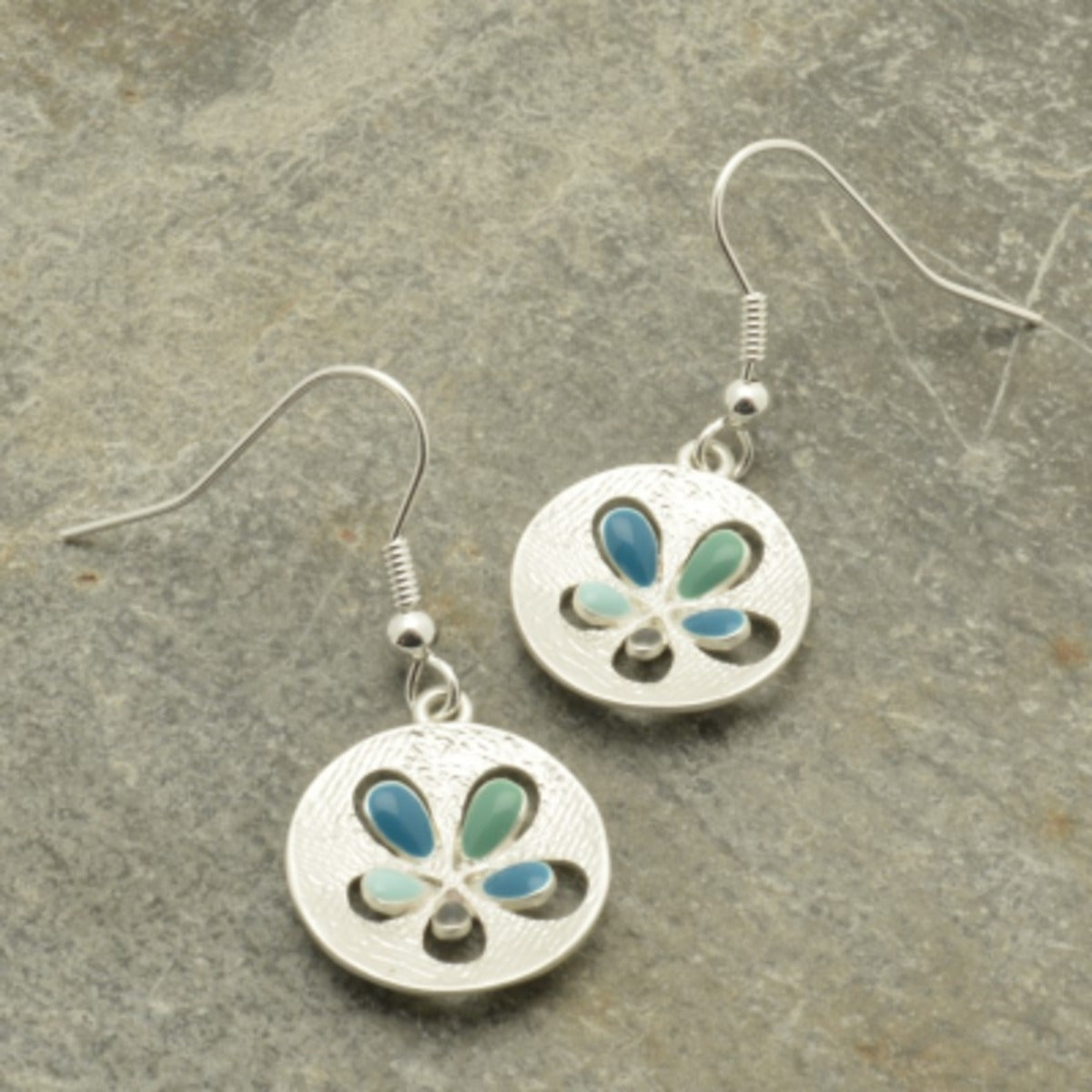 Make a statement with these stunning Aqua Popout Earrings! Petals of aqua, teal, mint and grey create intricate detail that stands out against a matt silver disc. Add a subtle pop of color that will elevate any look.  They measure approx 1.6cm in diameter and hang from fishhooks.