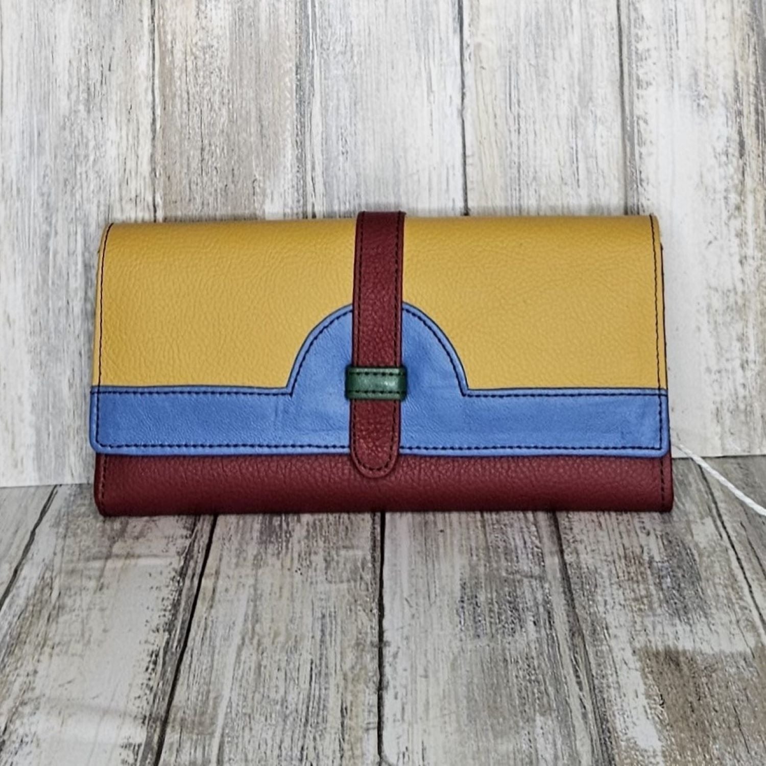 The Soruka Purse makes a bold statement with its vibrant colours and upcycled leather. Not only eco-friendly, this purse is also fair trade, ensuring ethical production methods. With plenty of card slots and a coin section, this colourful and soft leather purse is perfect for day-to-day use! Carrying your everyday essentials has never looked so good.  Each Soruka bag and large purse comes to you in a beautiful recycled Sari gift bag.  L:20.5cm W:2.5cm H:10cm