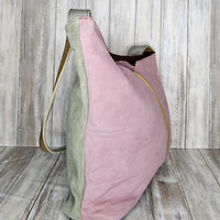 The Soruka Slouchy Bag with Zip is a unique work of art designed to elevate your look. Crafted with a beautiful combination of green and pink upcycled suede leather, this handmade bag designed in Barcelona will make you stand out from the crowd. Feel confident and stylish knowing your purchase directly supports fair-trade practices.  Each Soruka bag and large purse comes to you in a beautiful recycled Sari gift bag.  L:30 x W:8 x H24cm