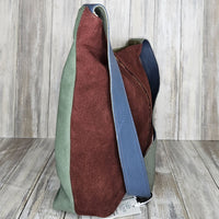 The Soruka Slouchy Bag with zip is a unique work of art designed to elevate your look. Crafted with a beautiful combination of burgundy and green upcycled suede leather, this handmade bag designed in Barcelona will make you stand out from the crowd. Feel confident and stylish knowing your purchase directly supports fair-trade practices.  Each Soruka bag and large purse comes to you in a beautiful recycled Sari gift bag.  L:30 x W:8 x H24cm