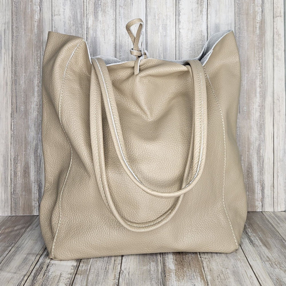 Experience luxury and organization with our pebbled leather Tote Bag! Made with soft Italian leather, this large tote features a convenient internal zip pocket and a stylish leather drawstring closure. Stay on-trend and chic with our fabulous taupe bag!