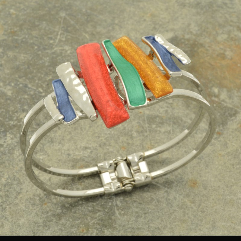 This elegant bracelet features an eye-catching combination of blue, green, mustard, and coral, finished with a reflective silver touch. Hinged to fit any size wrist, it's an ideal fit for any ensemble.