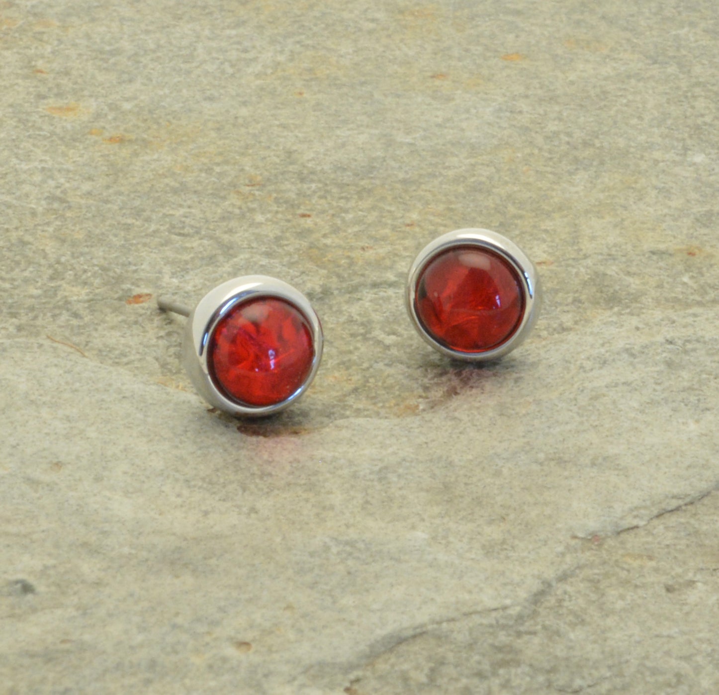 Love the classic look? Get timeless style with a modern twist with our Red Foil Resin Stud Earrings! Made with eye-catching red resin and a textured aluminum foil backing, these statement studs feature a gleaming silver surround. Elevate your look with this must-have accessory!  Approx 0.9cm in diameter, attached to posts and butterflies.