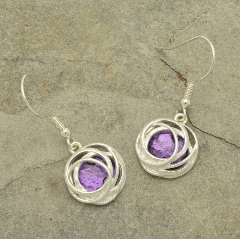 Make a bold statement with the Bright Purple and Silver Drop Earrings! These stunning earrings feature a beautiful bold purple resin backed by aluminium foil and surrounded by matt silver hooped metalwork, creating a unique and captivating blend of color and texture. Be glamorous and daring with these one-of-a-kind earrings!  These earrings are  approx 1.5cm in diameter and hang approx 2cm down from fishhooks.