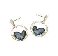 These statement earrings are a must-have for any stylish night out. The beautiful blue hearts, backed with aluminium foil, add depth and vibrancy, and look stunning against the sleek silver hoop.  2cm hoop drop from a silver bead,  and a silicon butterfly fastening.