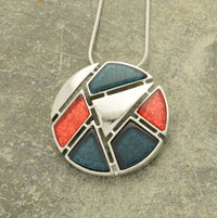 This beautiful necklace features a 3.8cm foil resin pendant rich in coral color, complemented by dark blue marble resin pieces and shiny silver accents. Finished with a 41cm necklace and 8cm extension chain, securely fastened with a lobster clasp.