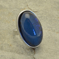 This Chunky Blue Foil Resin Adjustable Ring is the perfect addition to any jewelry collection. It boasts an eye-catching  blue color and a magnificent iridescent resin, adding an opalescent effect. Stylish and unique, it will coordinate with other Miss Milly jewellery and is adjustable for your convenience. Its dimensions are 3.3cm long by 2cm wide. Make a stylish statement with this beautiful ring!