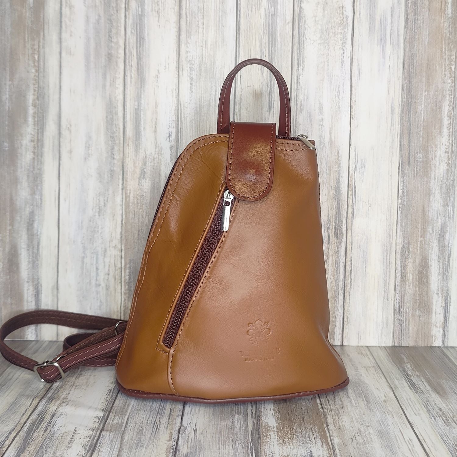 Another beautifully soft and lightweight leather Italian backpack, but this time a smaller version of our large backpack. This small backpack is equally as versatile and can be worn in the same main three ways, either by the loop handle at the top, over one shoulder, or by unzipping the strap and wearing as a classic backpack. You can also unclip the straps of these smaller ones and wear them as a cross body!  Each bag is fully lined with front, back and inside pockets.   w22cm x d23cm x h12cm