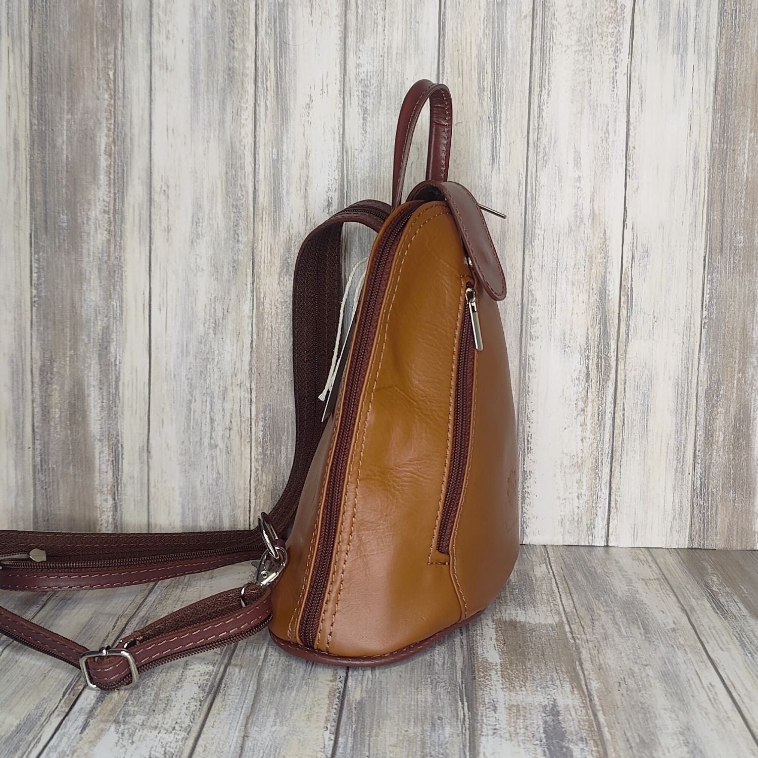 Another beautifully soft and lightweight leather Italian backpack, but this time a smaller version of our large backpack. This small backpack is equally as versatile and can be worn in the same main three ways, either by the loop handle at the top, over one shoulder, or by unzipping the strap and wearing as a classic backpack. You can also unclip the straps of these smaller ones and wear them as a cross body!  Each bag is fully lined with front, back and inside pockets.   w22cm x d23cm x h12cm