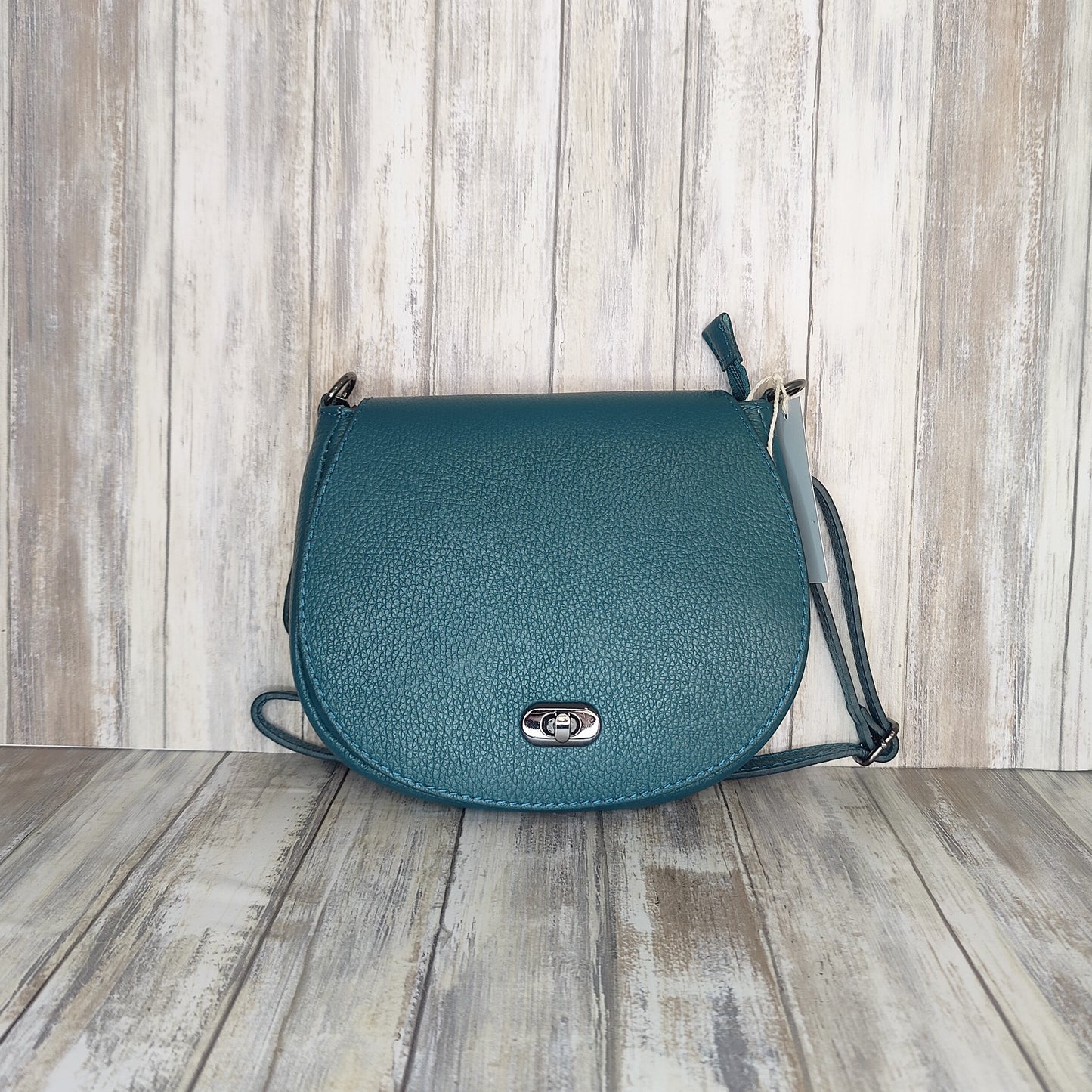 This elegant yet practical saddle bag is crafted from luxuriously soft Italian leather and features a flat silhouette with a postman's lock and zipper closure. The adjustable length strap makes it perfect for carrying as a shoulder bag or cross body.   Outer pocket with zip   Internal zip pocket   Adjustable detachable strap   Silver Hardware   L:23cm x H:16cm x W:4cm
