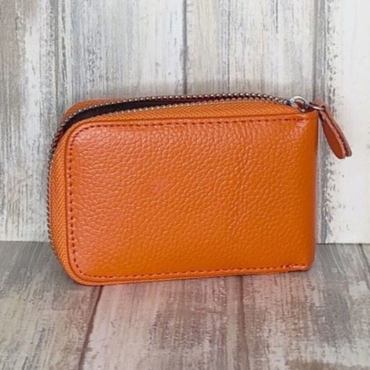 This classic leather card holder features 12 card slots for easy organization. It also includes a single zip and enough space to store a few notes or receipts. Made from premium pebbled leather, it is lightweight yet durable, offering a perfect balance of style and convenience.