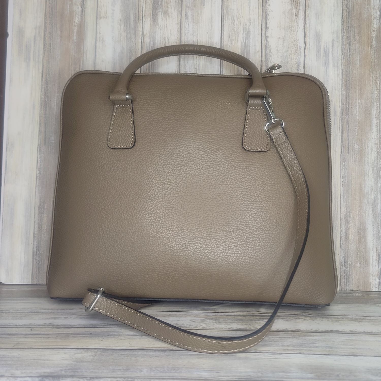 Make an impact with this sleek, unisex Italian leather laptop bag. With an adjustable shoulder strap it will fit perfectly. And you'll love the convenience of the interior laptop pocket, inner zip pocket, and exterior zip pocket. Stand out in style!  w:34cm x h:29cm x d:7cm