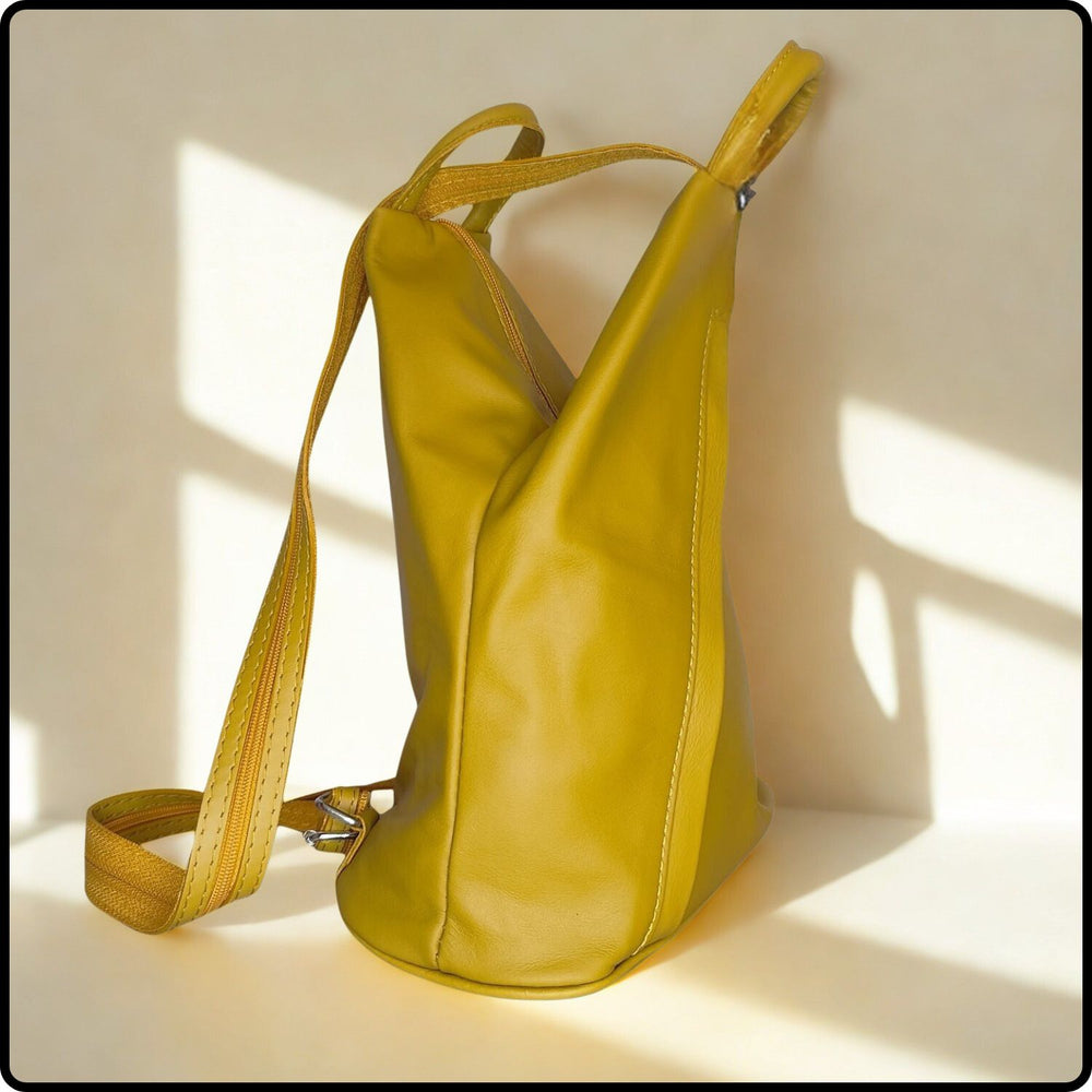 Yellow leather handbag with a strap on a light background