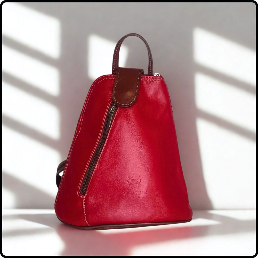 Red leather backpack with brown accents on a light background