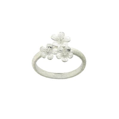 This is a simple brushed silver band ring featuring 3 delicate flowers. Perfect to wear on its own or as a stacking ring.  The width of the decorative design of the ring is 13mm, height 10mm and the depth is 2mm. The width of the band is 3mm. All measurements are approximate and measured at widest/longest point.  Delivered gift boxed.