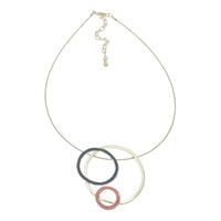 This stylish navy blue, pink, and imitation silver hoops necklace is a perfect way to add modern glamour to any outfit. Its geometric design and single wire give it a subtle yet eye-catching effect, allowing you to sparkle with effortless sophistication.  41cm or 16″ long and fastens with a lobster clasp and 8cm extension chain. The pendant measures approx 5cm in diameter.