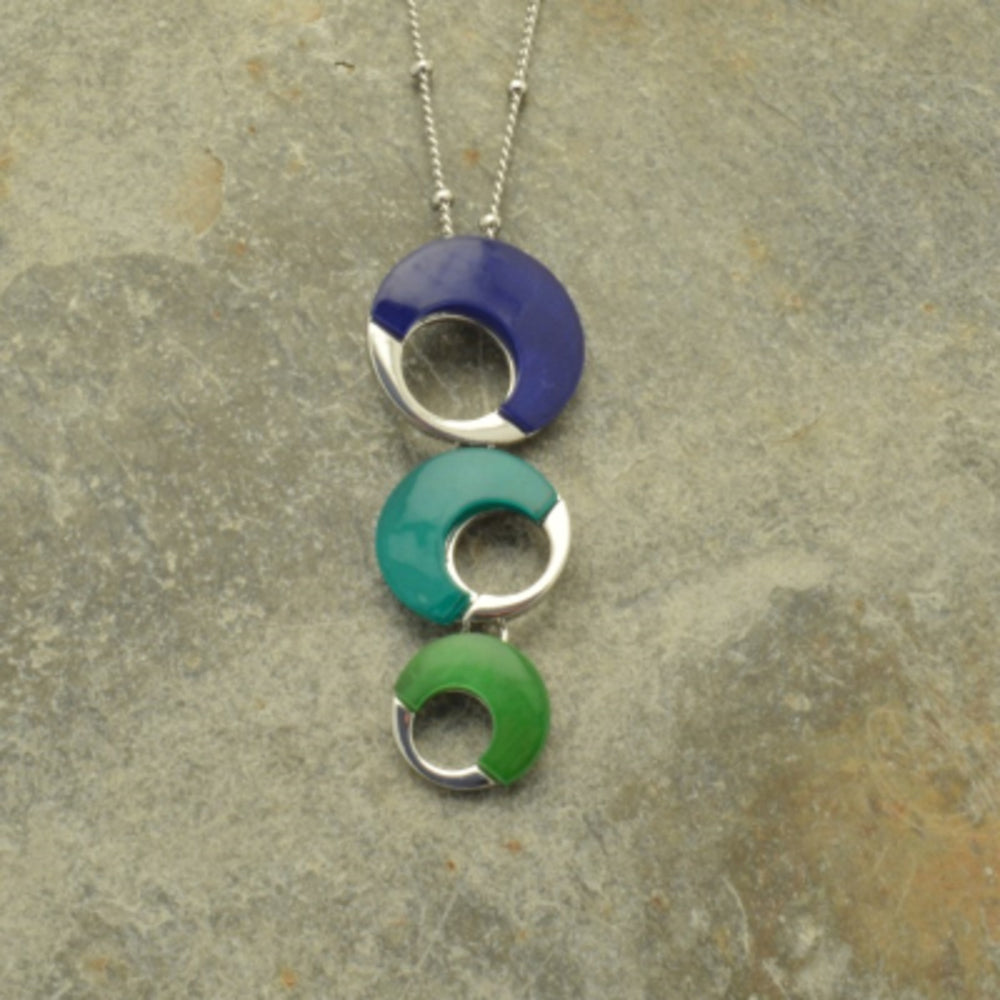 This Sea Shell Necklace will quickly become one of your favorite accessories! Crafted with thin veneers of blue, teal and lime green shell, the intricate details and striking colours make it an eye-catching piece. With its handmade design, it's the perfect way to showcase your individual style and shine!  This pendant measures 6cm x 2cm and hangs from a 41cm necklace that fastens with a lobster clasp and 8cm extender.